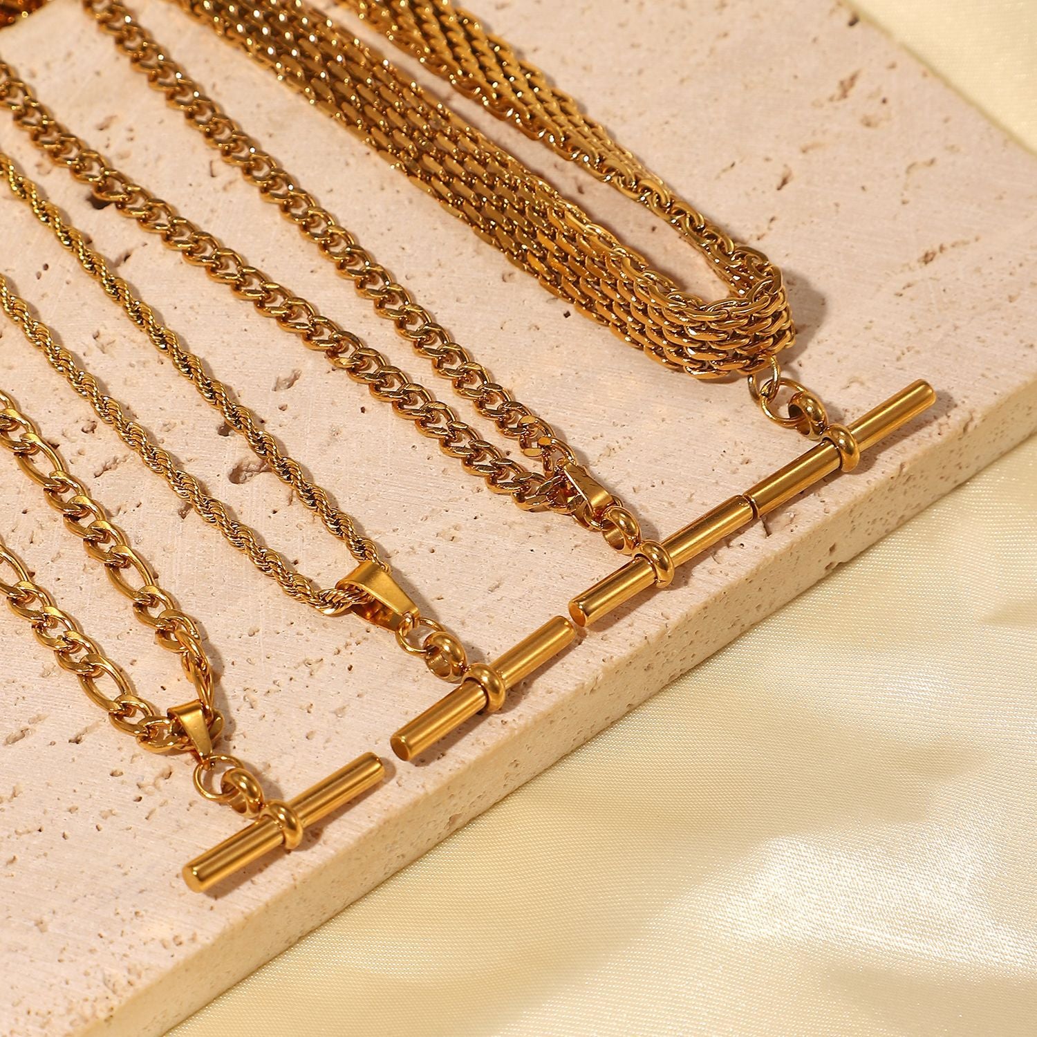 Gold T-bar pendant necklace with Figaro chain on model
