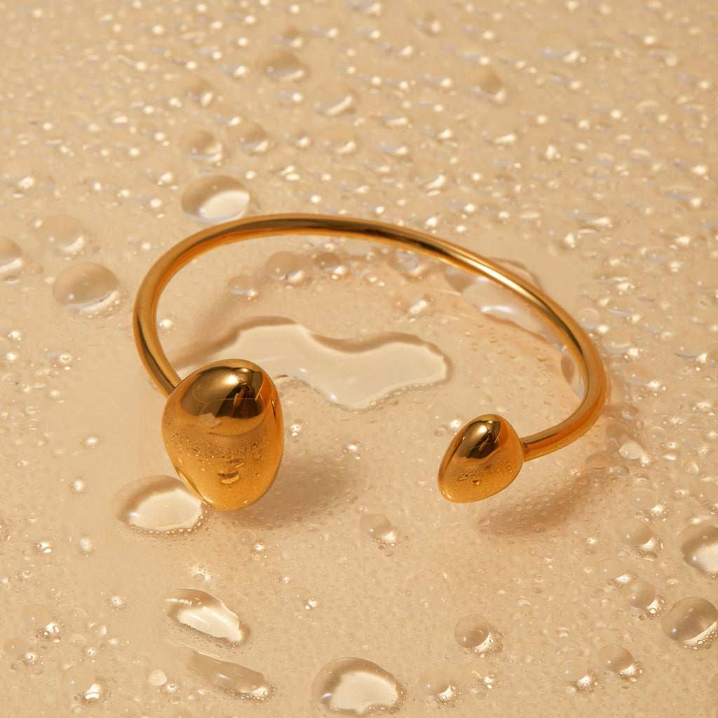 Close up of polished gold open cuff bracelet with smooth metallic finish