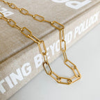 Gold paperclip necklace layered with delicate chains