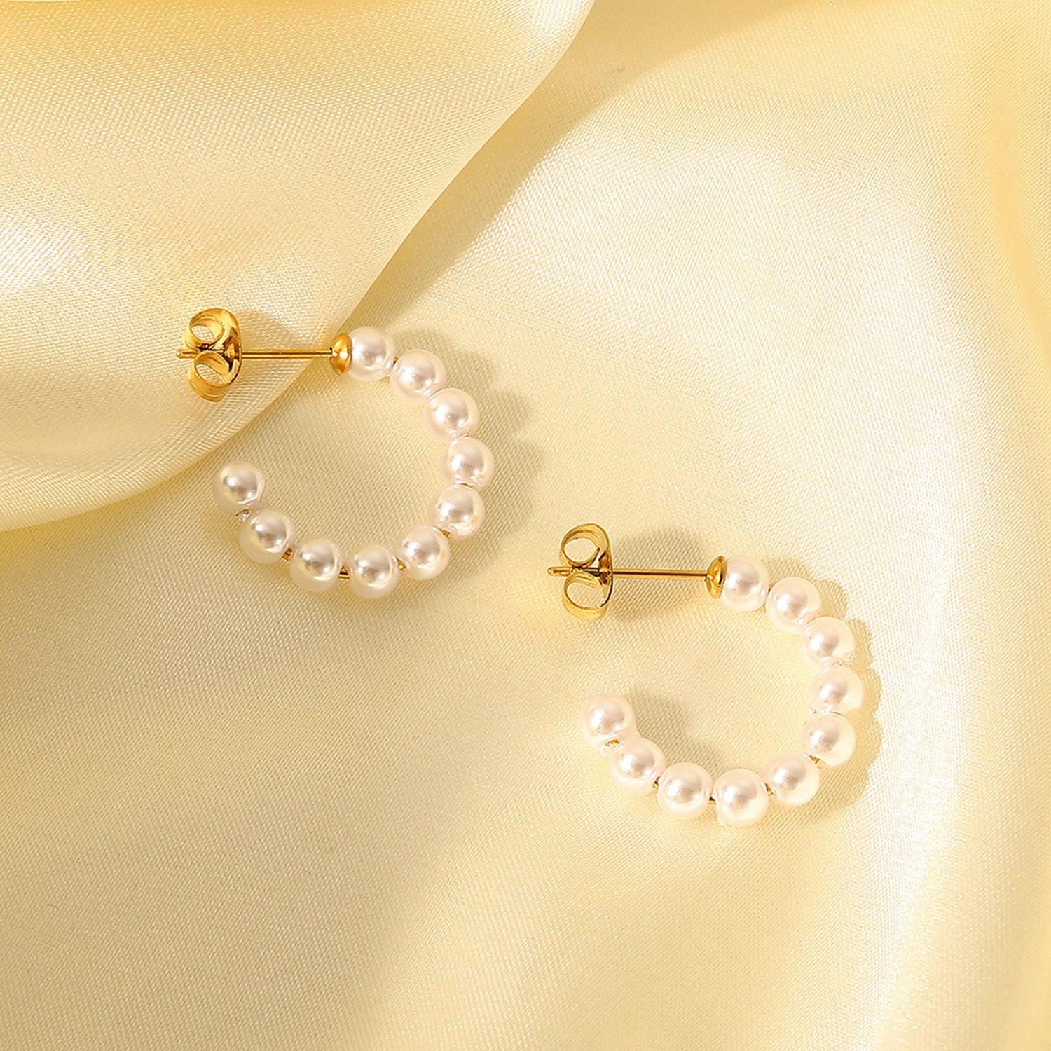 Gold C-shaped hoop earrings with small white pearls for women