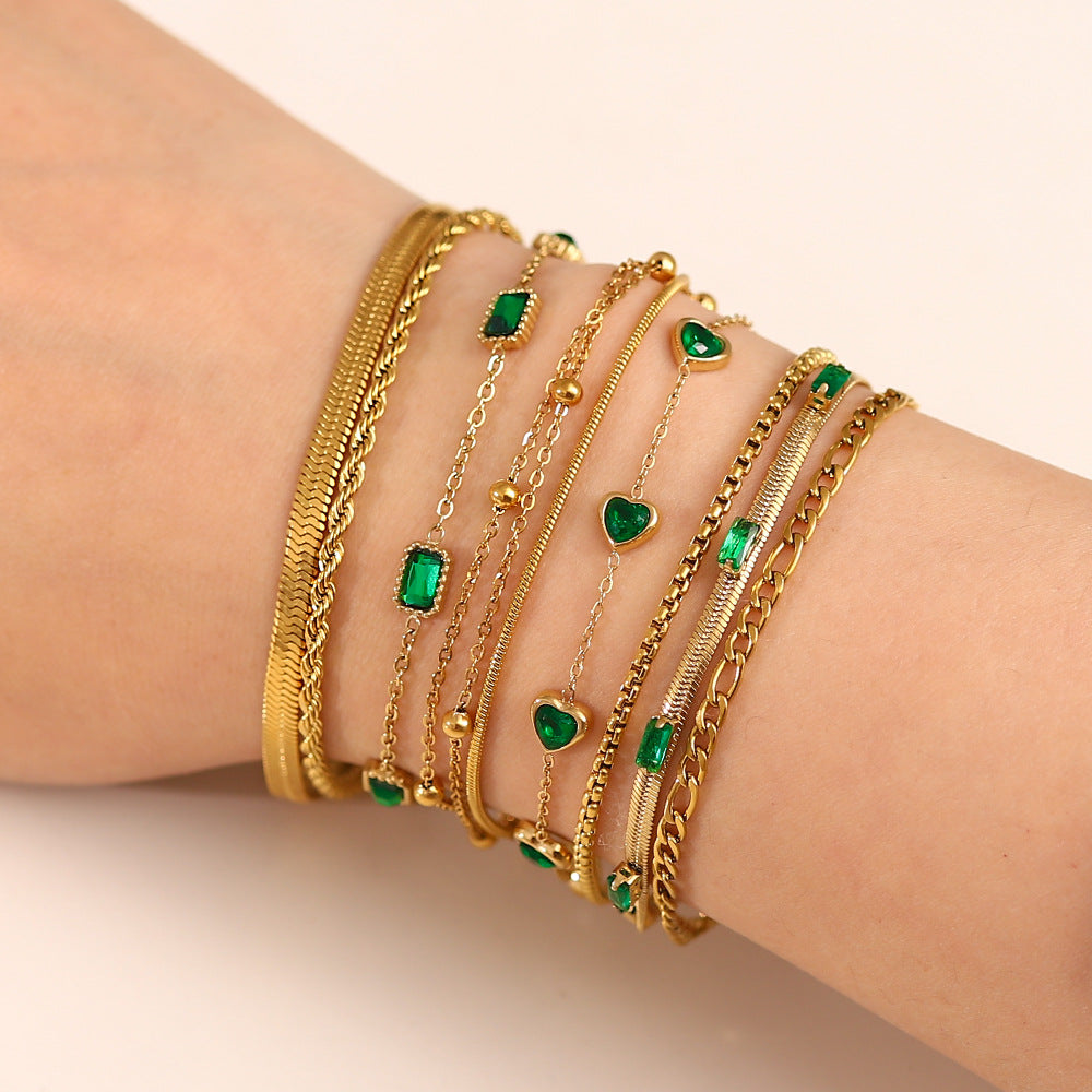 Gold green layered charm bracelet on wrist